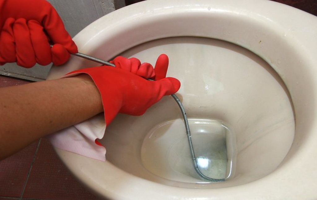 cleaning the toilet with a cable