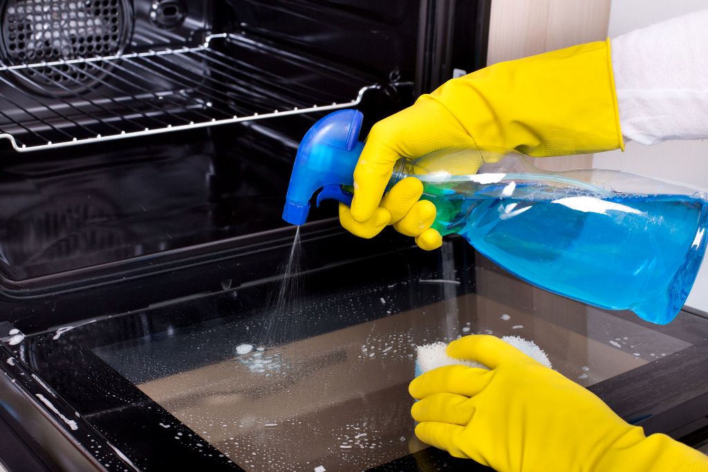 cleaning the oven with a spray