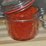 glass jar with red caviar on the table