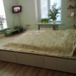 podium bed with yellow bedspread