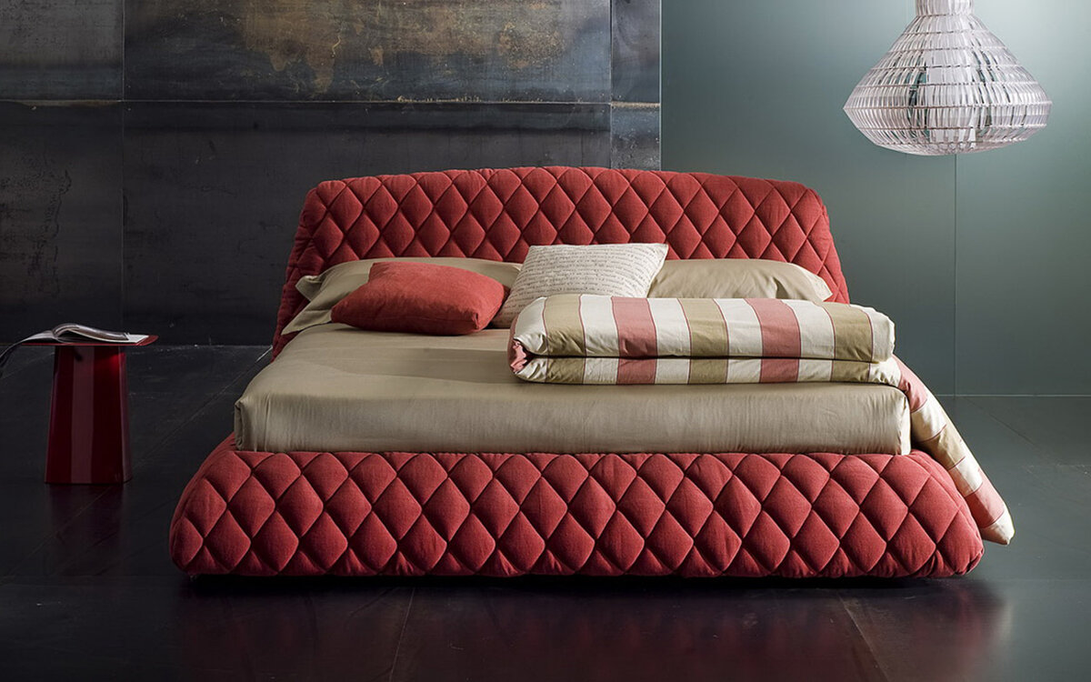 bed with a soft quilted headboard