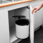 cabinet under the sink with a bucket