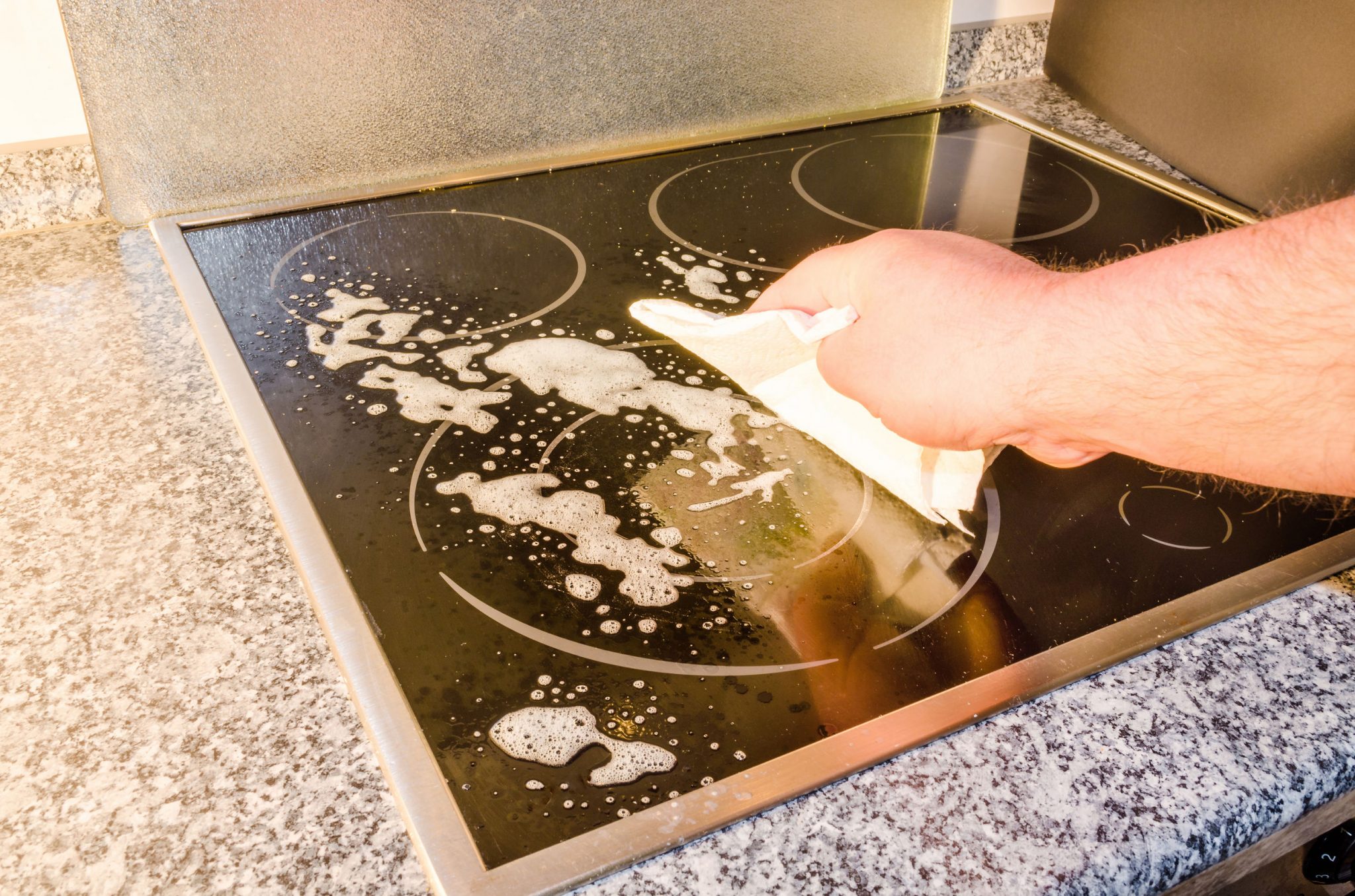 cleaning the stove with a rag