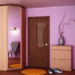 corner wardrobe in the hallway with a round carpet