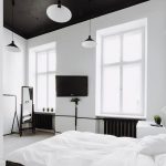 spacious bedroom with dark furniture and white walls