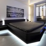 bedroom with a dark bed with lighting