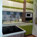 green kitchen with black stove