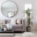 round mirror above the sofa