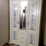 decor of a white three-door wardrobe