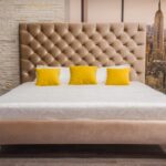 bed with headboard with yellow pillows