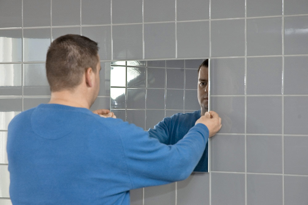 fixing the mirror on the wall with glue photo