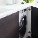 washing machine in the kitchen with a shelf