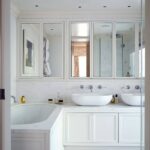 built-in wardrobe in the bathroom mirrored above the washbasin