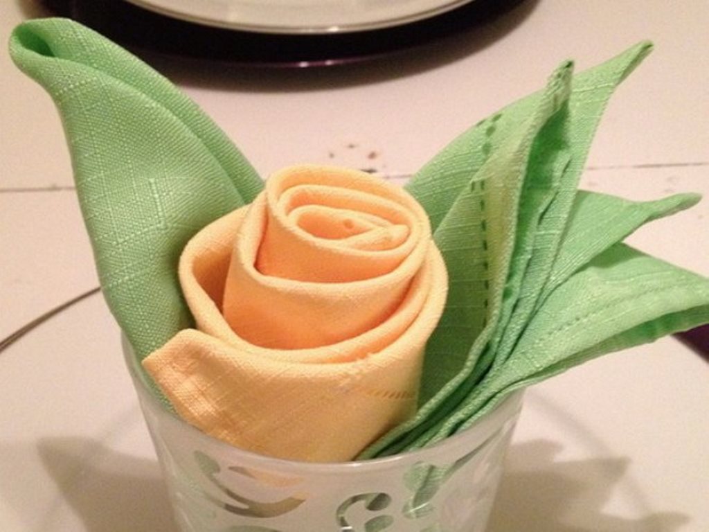 rose from a napkin in a glass