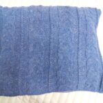 blue pillow on knitting needles