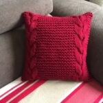 pillow on knitting needles burgundy with braids